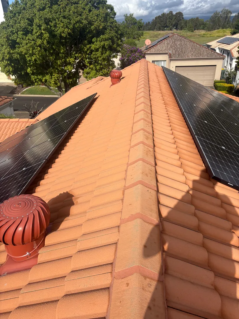 Roof plumbing inspection on a terracotta tiled roof with solar panels on the Gold Coast